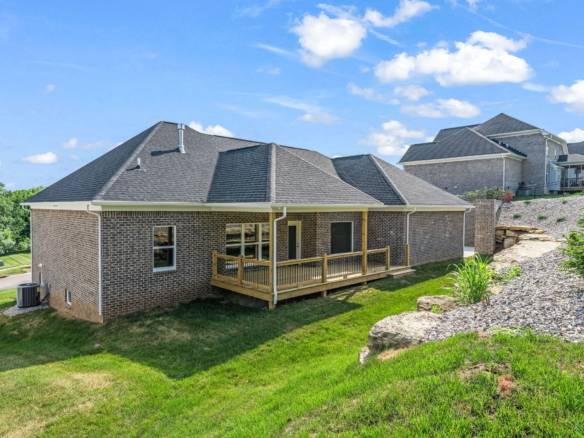 Beautiful new brick home with a wooden deck in a suburban neighborhood.