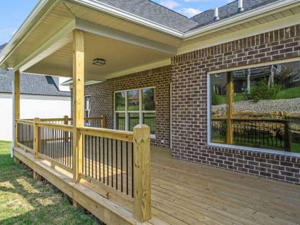 Deck extension with wooden railing at the back of the house.