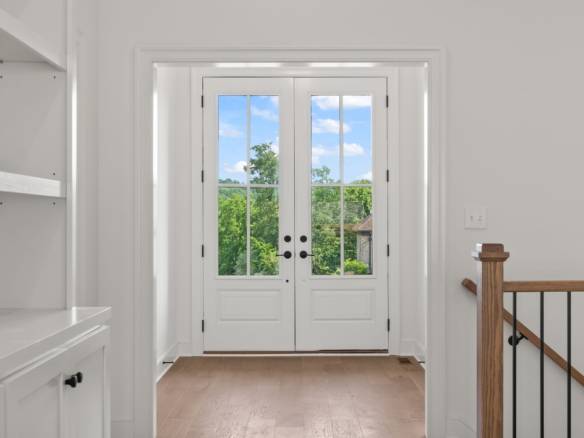 Beautiful white front door with glass panels and scenic view.