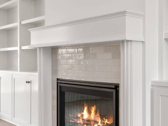 Fireplace with white mantel and built-in shelving units in a contemporary living room.