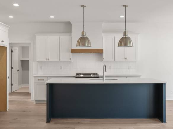 Bright modern kitchen with white cabinets and dark island, new construction at 5609 Morningside Driv.