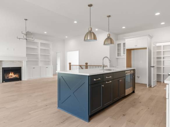 Spacious kitchen featuring a central island with dark cabinetry and pendant lighting.
