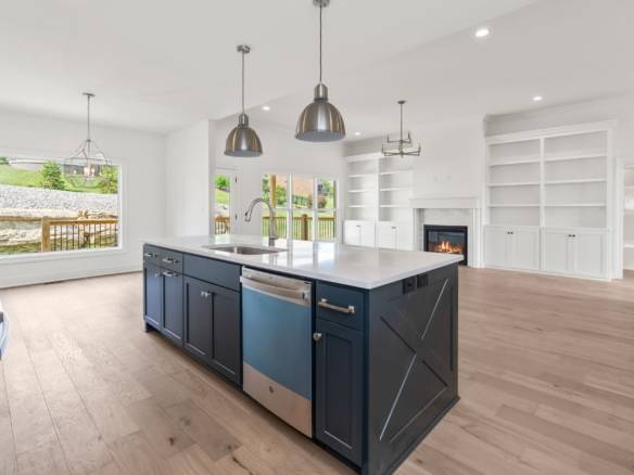 Bright, open-concept kitchen with a navy blue island and large windows.