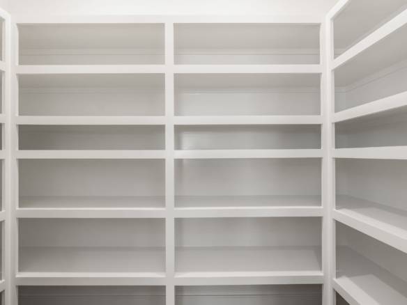 Empty white built-in shelves in a modern storage room.