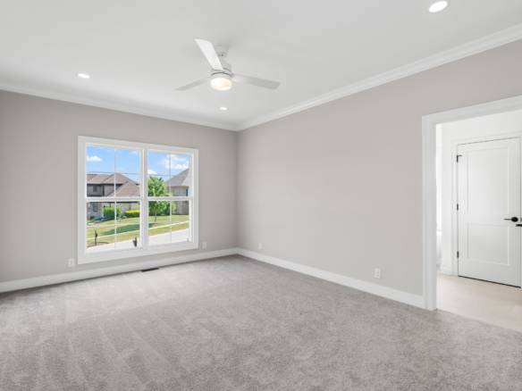 Bright, spacious bedroom with large window and neutral decor.
