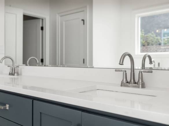 Modern kitchen with white countertops and blue cabinets.