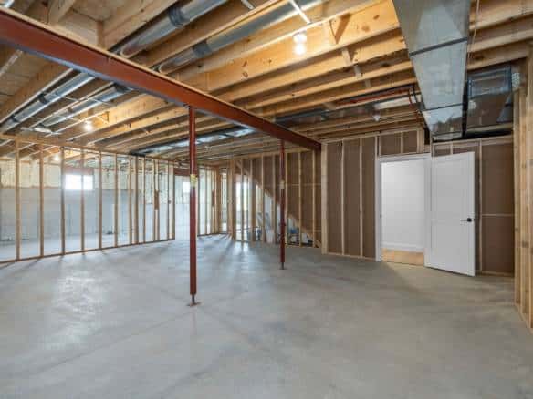 Interior view of a newly built basement with unfinished walls and ceiling.