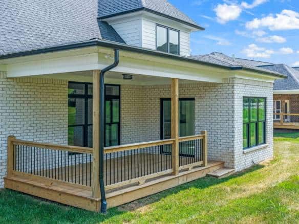 Porch construction on a Morningside Drive house with black-framed windows and white brick exterior.