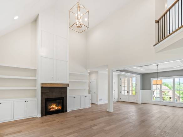 Spacious interior featuring a fireplace, white walls, and natural light.