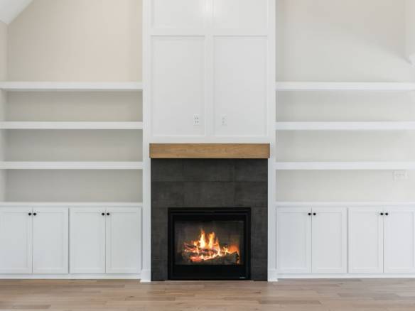 Elegant fireplace with white shelving units on both sides, creating a cozy and stylish focal point.