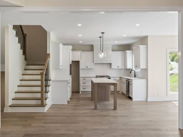 Bright, open-concept kitchen with white cabinetry and a central island.