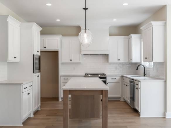 White kitchen with island, cabinetry, and appliances at 5611 Morningside Drive.