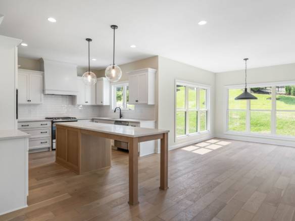 Spacious open-concept kitchen and living room with large windows and natural light.