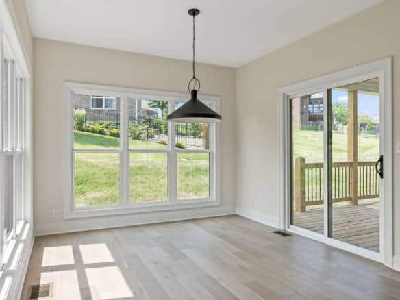 Bright living space with expansive windows and a sliding door leading to a deck.