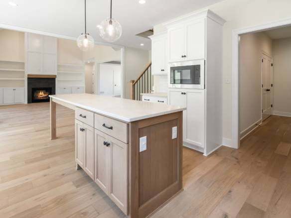Bright, spacious kitchen featuring white cabinetry and a central island for cooking and gathering.