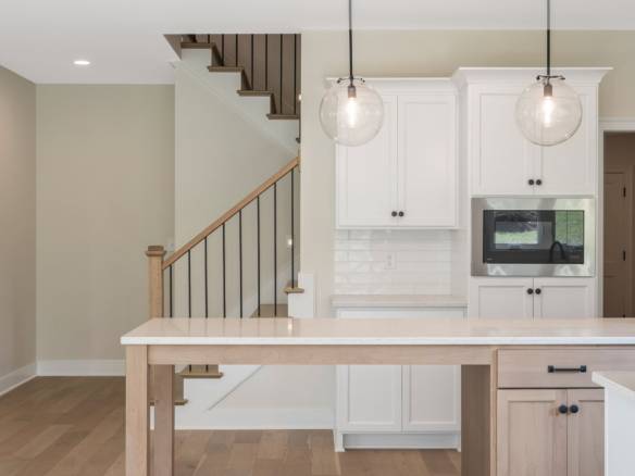 Modern kitchen with white cabinets and pendant lighting.