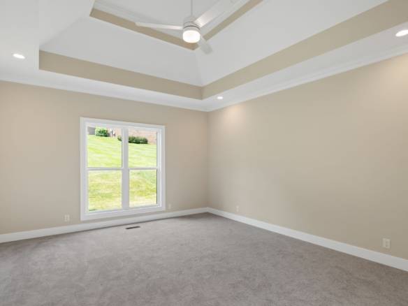 Bright, spacious living room with tray ceiling and large window.