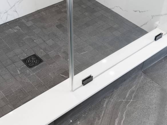 Glass shower door with black hardware and clear glass panels.