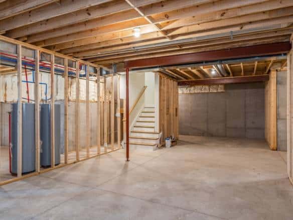 Underground basement framing and plumbing installation in progress at a residential property.