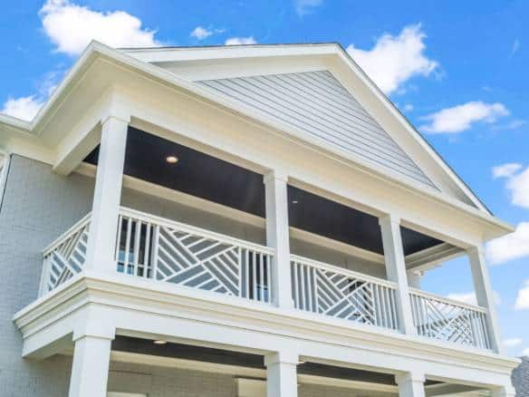 New construction home with spacious balcony and white exterior siding.
