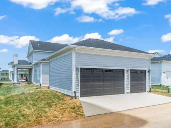 New construction home with blue siding and double garage in Pond Lily Street.