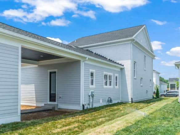 Modern home exterior with white siding and gray roof.