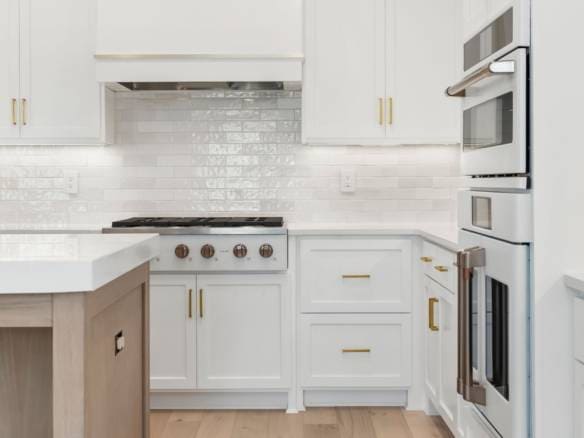 Bright white kitchen with sleek cabinetry and modern appliances.