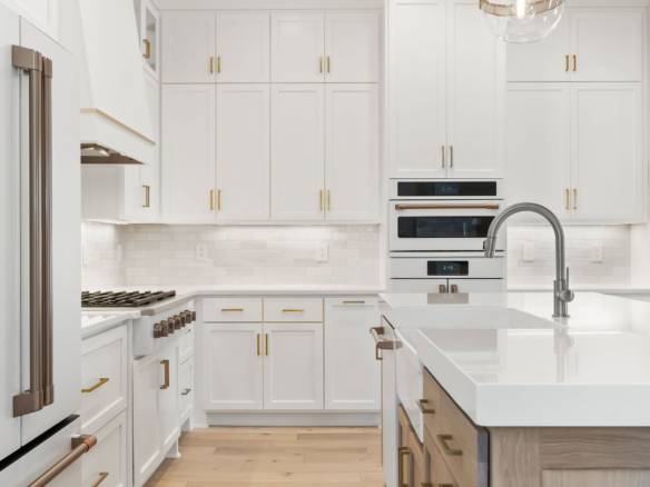 Bright white kitchen featuring sleek cabinetry and gold hardware details.