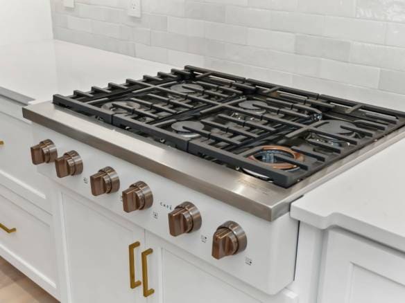 Gas stove with five burners in a contemporary kitchen setting.