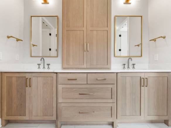 Bathroom vanity with dual sinks and wooden cabinetry.
