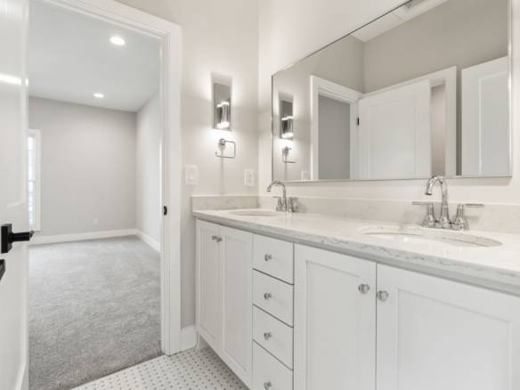 Bathroom vanity with dual sinks and large mirror in a contemporary home.