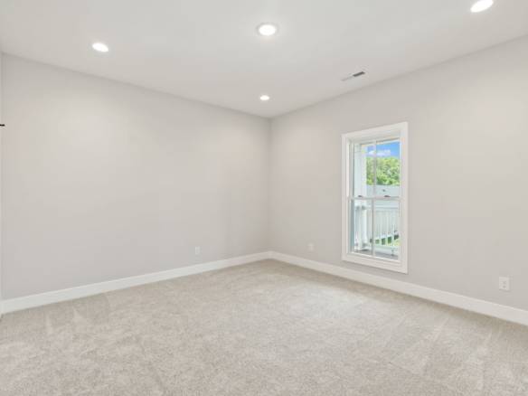 Interior view of a bright, spacious room with white walls and a large window at 6331 Pond Lily Stree.