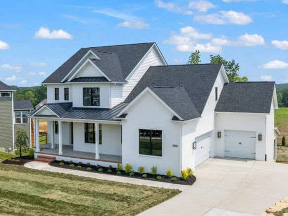 New white house with front porch and attached garage at 17423 Shakes Creek Drive.