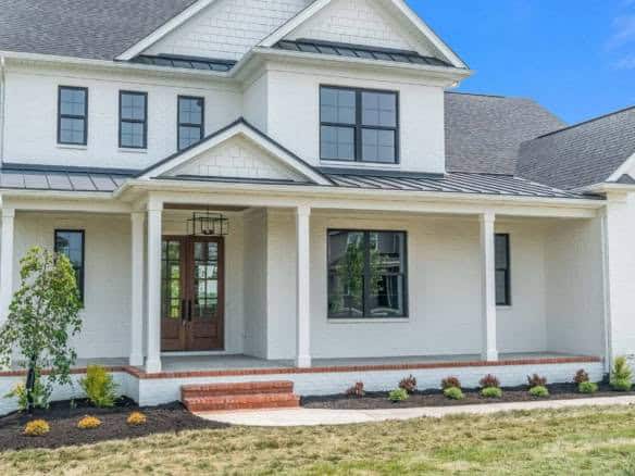 New white house with front porch and landscaped yard in Shakes Creek Drive.