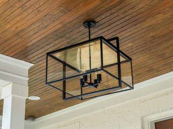 Ceiling light fixture with black metal frame and glass panels in a modern interior.
