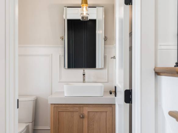 Bathroom vanity with vessel sink and wall mirror in a contemporary home.