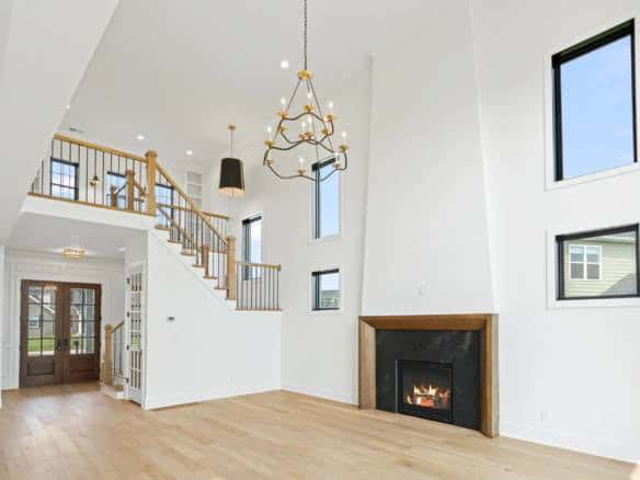 Spacious living room featuring a fireplace, high ceilings, and large windows for natural light. Perf.