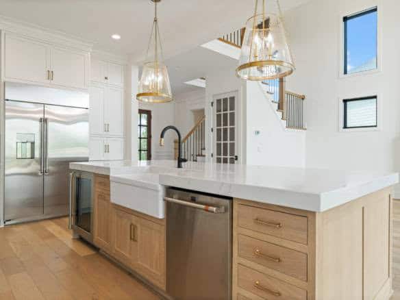 Bright, spacious kitchen featuring white cabinetry, a large island, and stainless steel appliances.