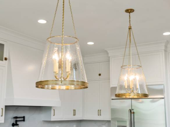 Gold chandelier lighting fixtures in a contemporary kitchen setting.