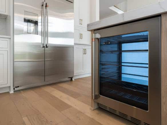 Stainless steel refrigerator and wine cooler in a contemporary kitchen setting.