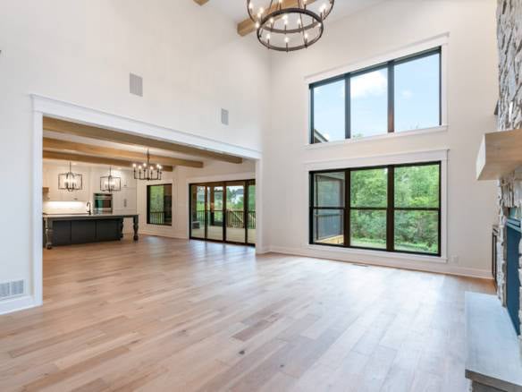 Spacious living area with large windows, high ceilings, and natural light in a new home at 11105 Cra.