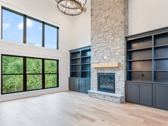 Modern living room with large windows and a stone fireplace.