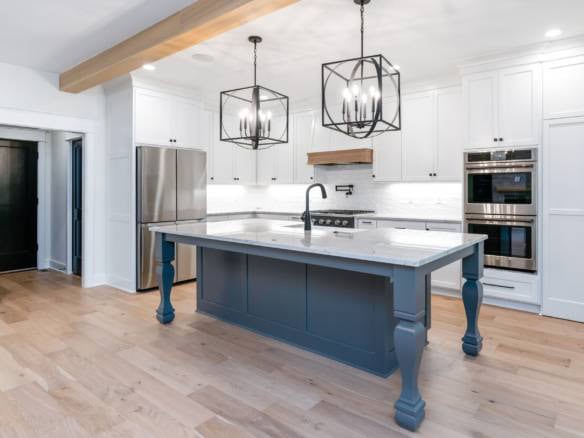 Bright, spacious kitchen featuring white cabinetry and a central blue island.