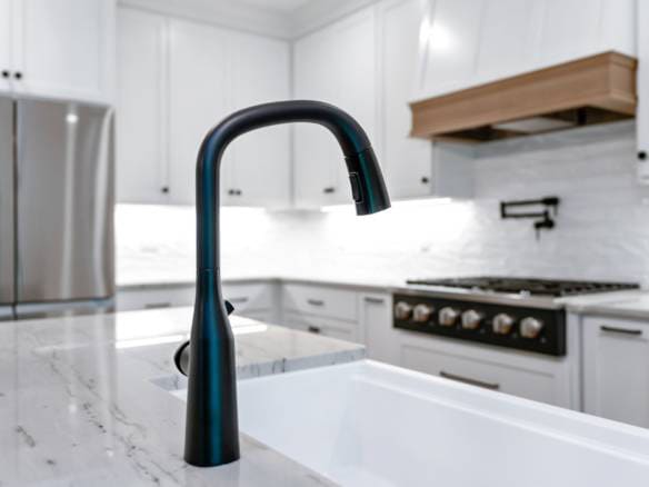 Bright kitchen featuring a sleek black faucet, white cabinetry, and modern appliances.