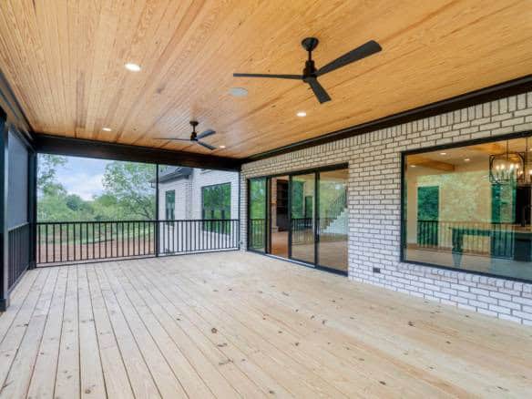 Covered porch with wooden flooring and ceiling fans at 11105 Craigs Creek Court.