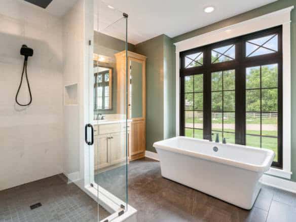 Bathroom with large window, walk-in shower, and freestanding tub.
