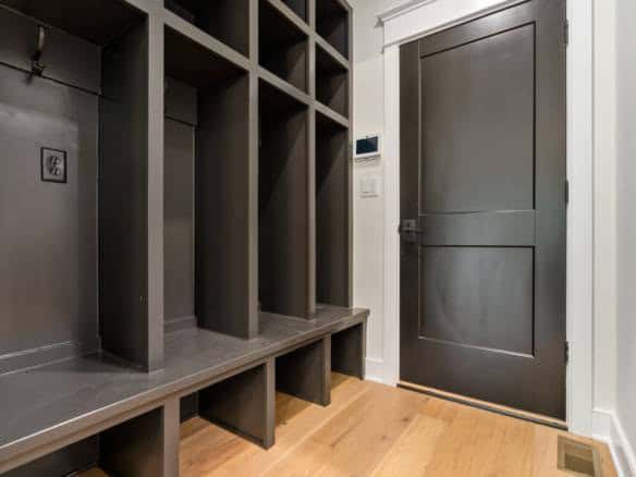 Custom mudroom storage with cubbies and bench in a contemporary home.
