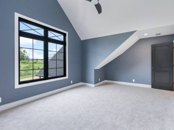 Bright interior featuring a spacious bedroom with a large window and sloped ceiling, showcasing qual.