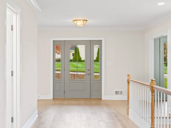 Bright and welcoming front entrance with double doors and large windows.