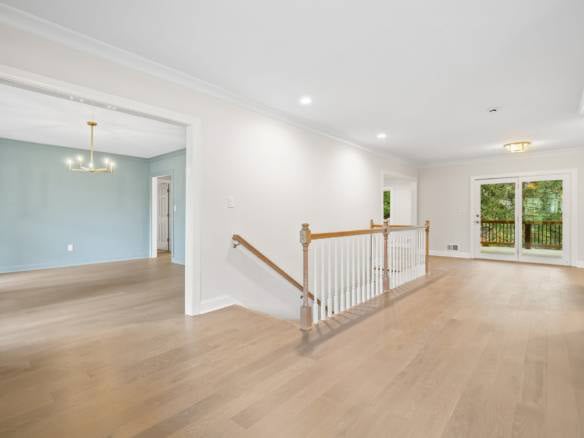 Spacious living area with hardwood floors, large windows, and access to a balcony, showcasing the qu.